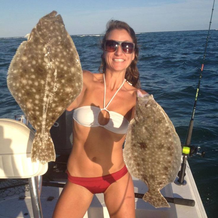 A woman with two fish who took off her fishing t short to get more sun